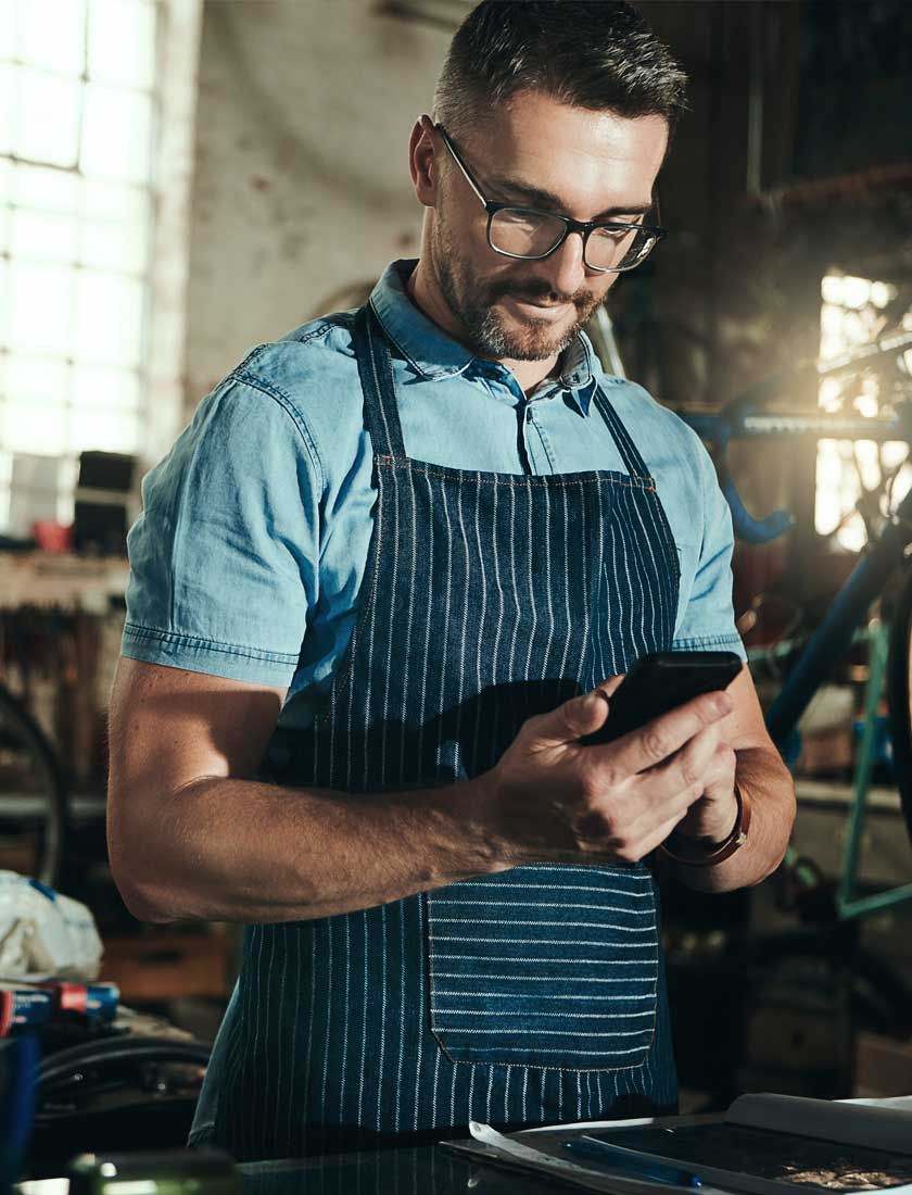 small business employee reviewing his business account with free mobile banking app